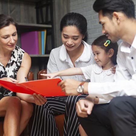 Happy young diverse family speaking with professional